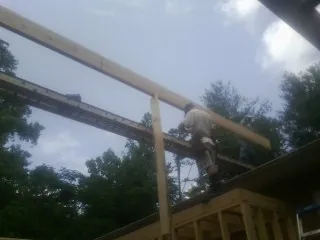 Carpenter setting a ridge beam over a new addition frame — Ice Dam Removal by Roofing Brothers in Ponce De Leon