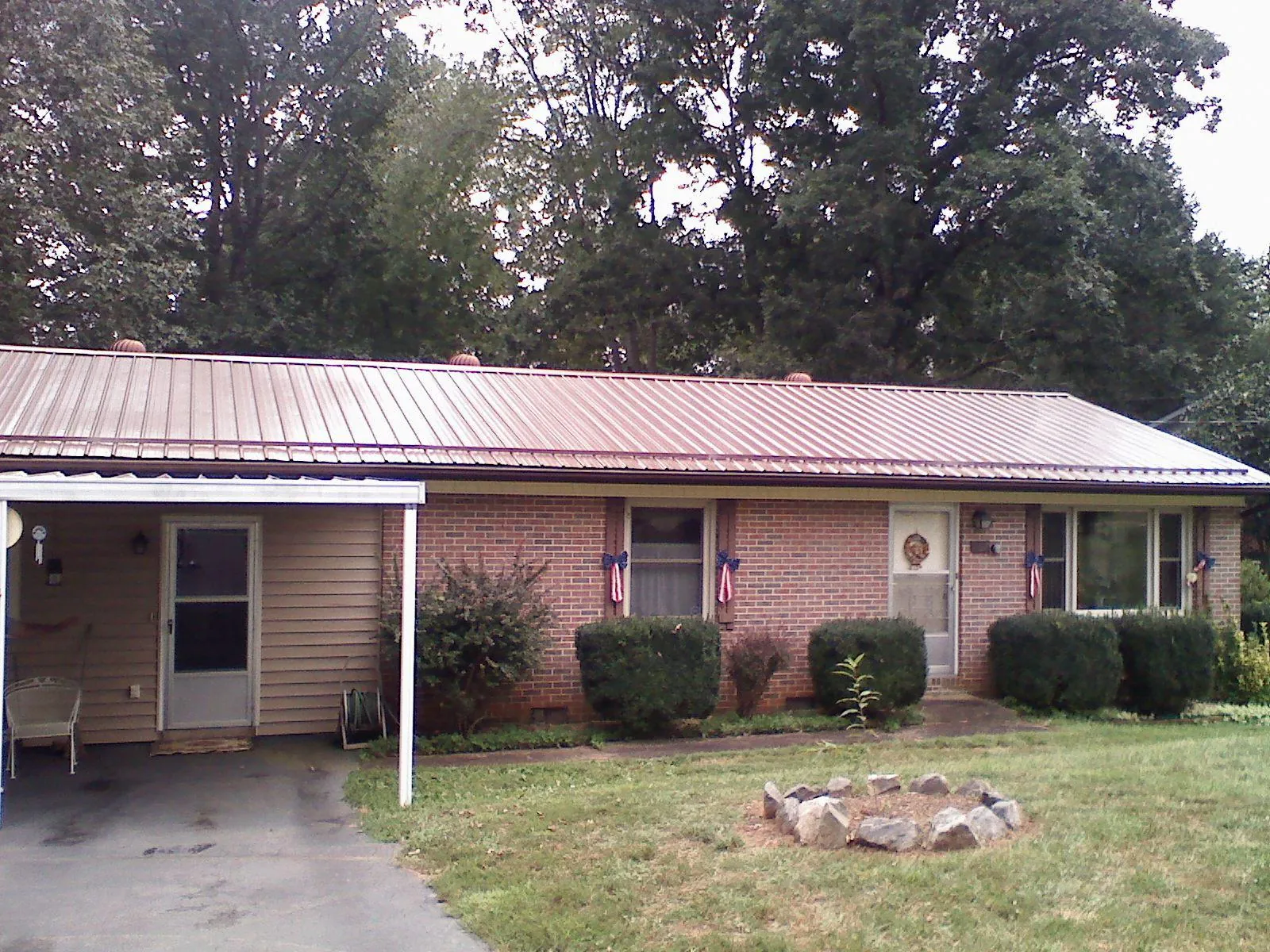 Bronze metal roof and carport on a brick ranch home — Roof Repair work by our crew in Ponce De Leon