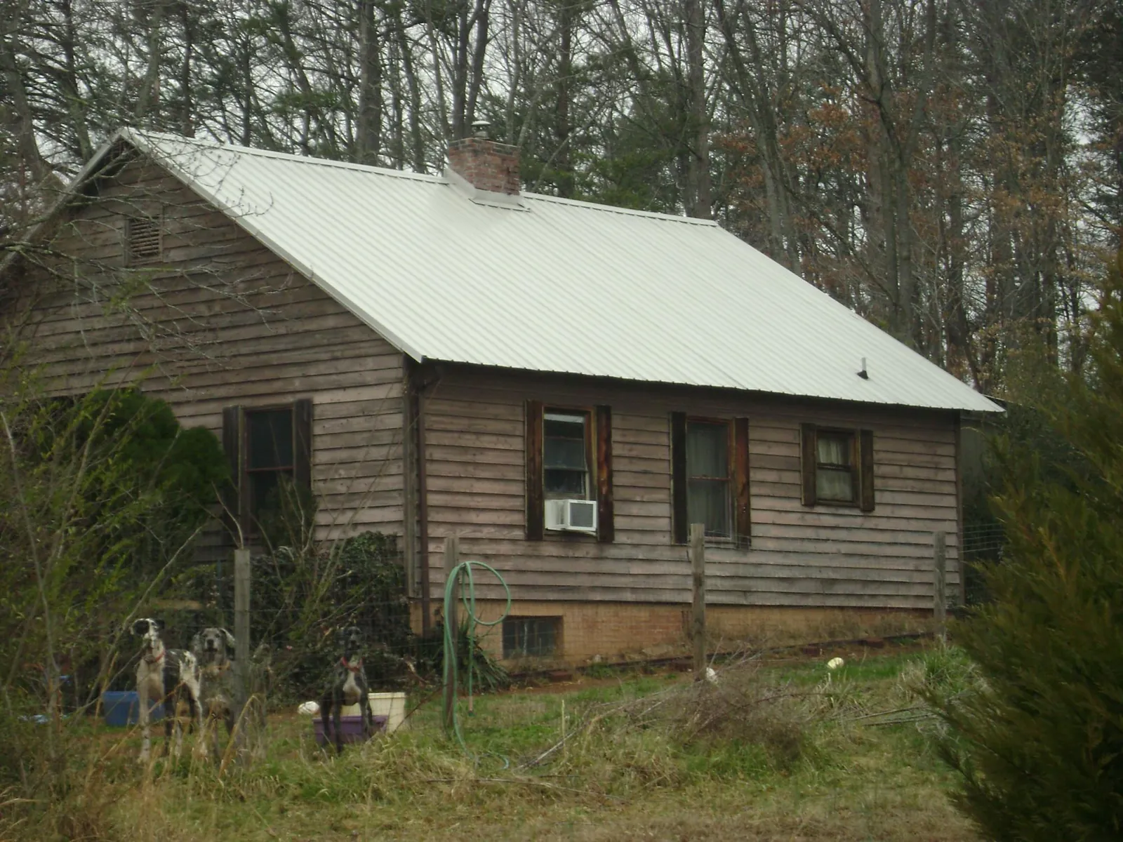 White metal roof on an old wood sided farmhouse, from a Metal Roof Installation job in Ponce De Leon